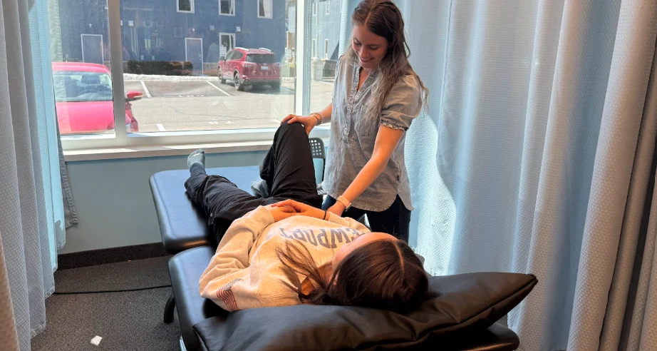 Physiotherapist assessing patient’s leg for IT Band pain in clinical setting Physiotherapy Oakville