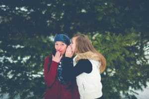 two girls sharing a secret