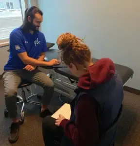 Sheddon Physiotherapy Oakville — physiotherapist assessing a student athlete for sports injury prevention and rehab